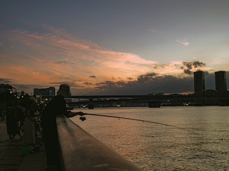 Fisherman casting line into river at sunset — photo from Unsplash