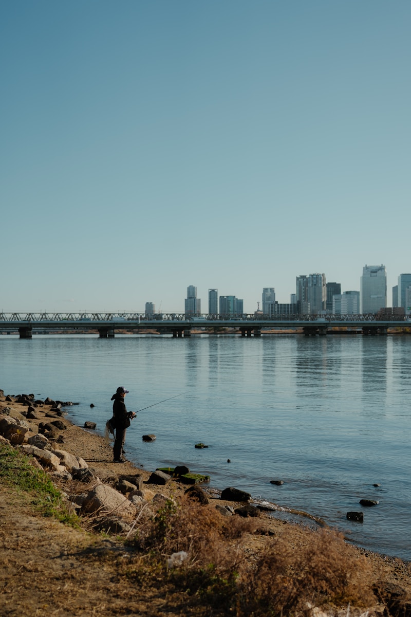 Fisherman casting line by river — photo from Unsplash