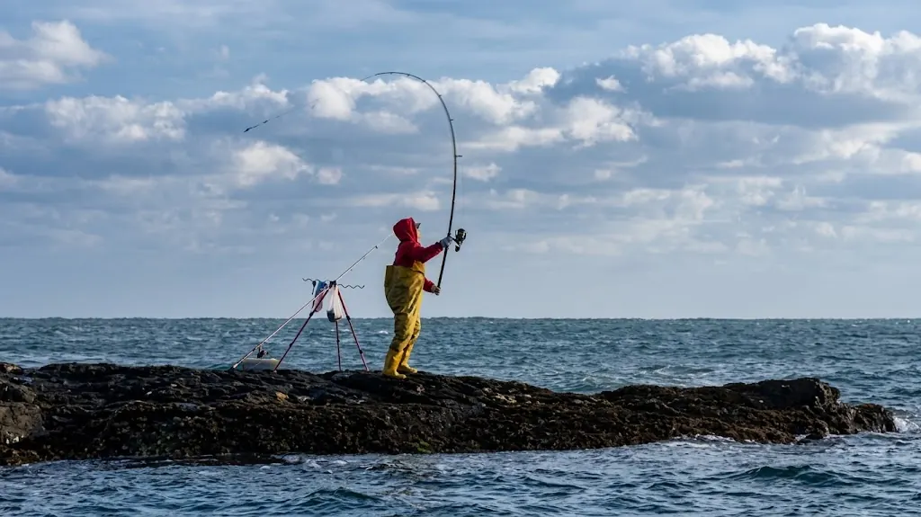 Anglers fishing the rocks where a river meets the sea